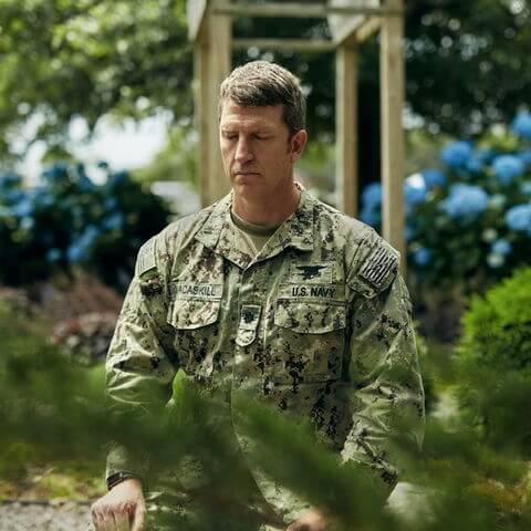 Jon Macaskill meditating, kneeling, in his Navy uniform