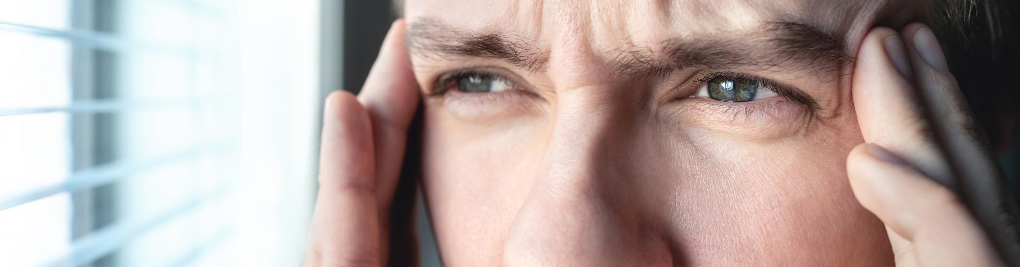 man rubbing his temples