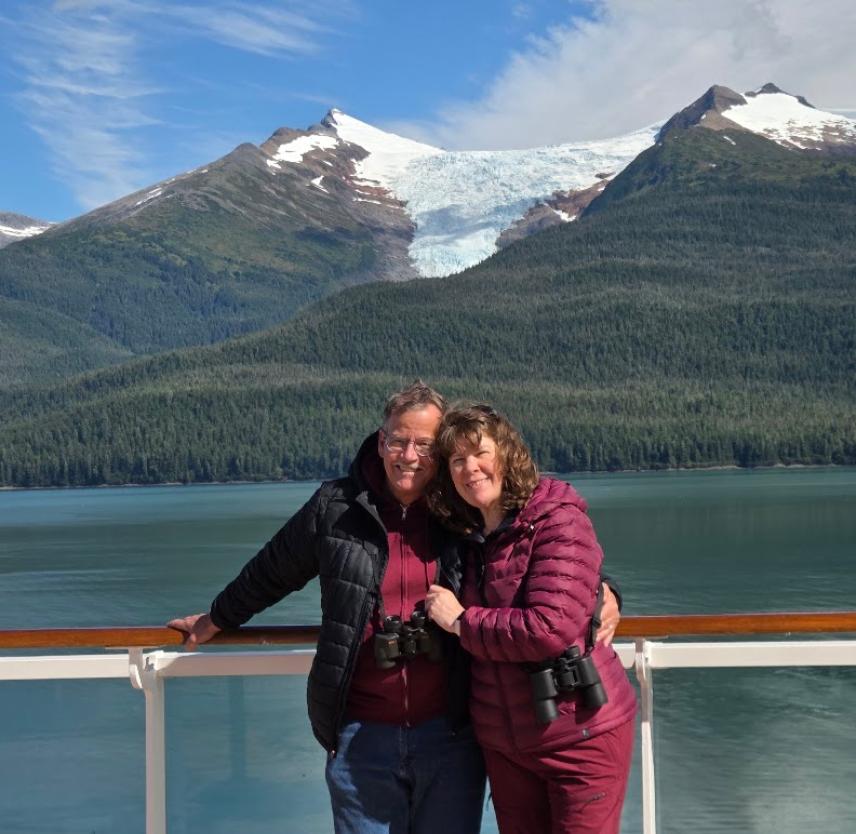 David and his wife in front of a mountain.