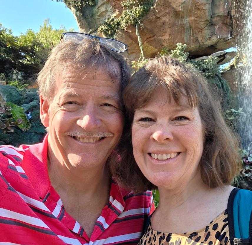 David Grant and his wife smiling at the camera.