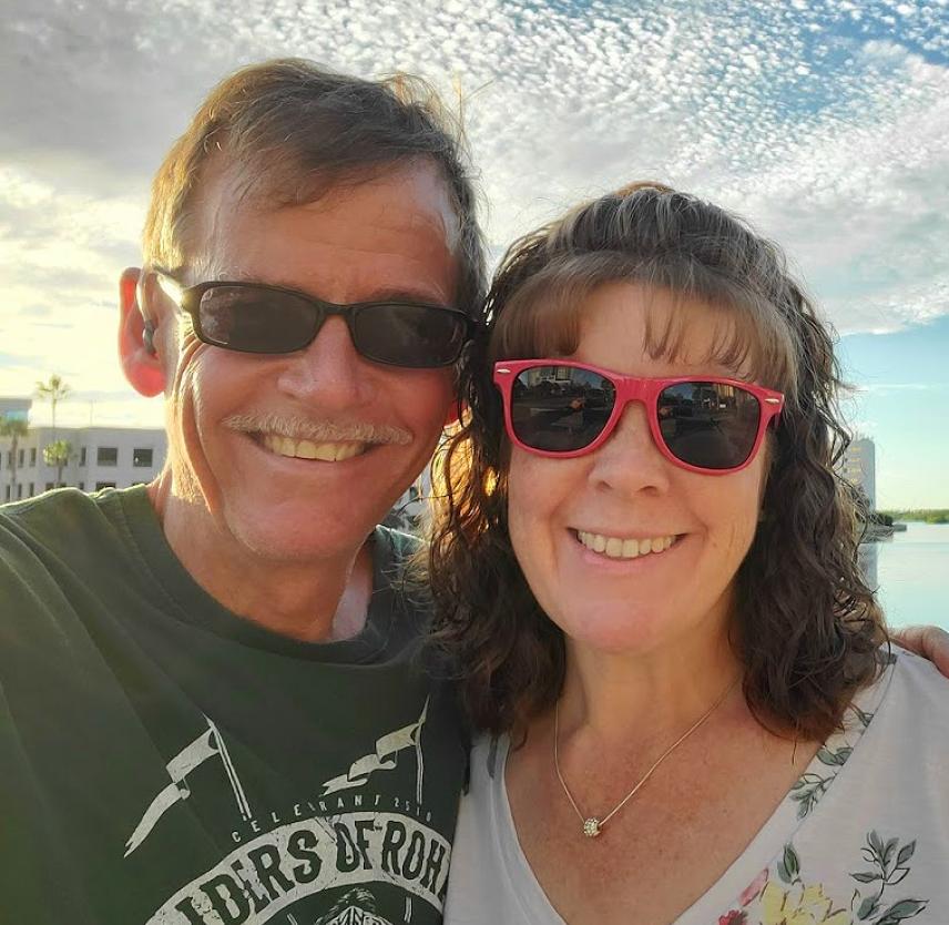 David Grant and his wife on vacation David Grant and his wife wearing sunglasses, smiling in front of a tropical lagoon