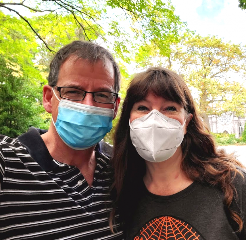 David Grant and his wife smiling in face masks David Grant and his wife smiling in face masks