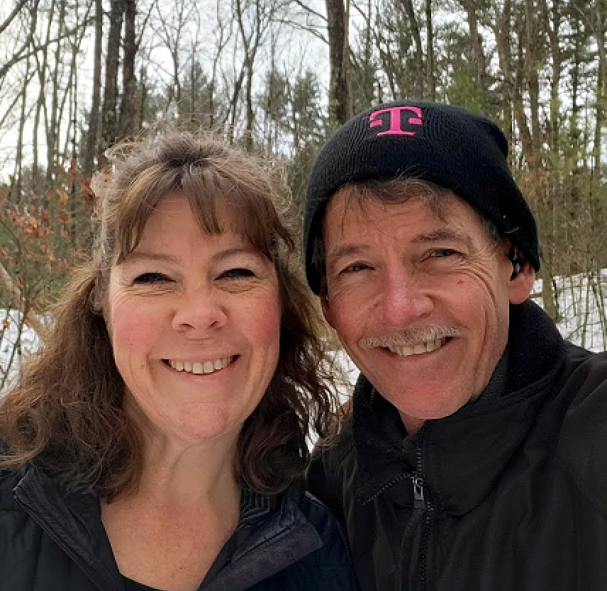 David and his wife smiling in a wintery forest