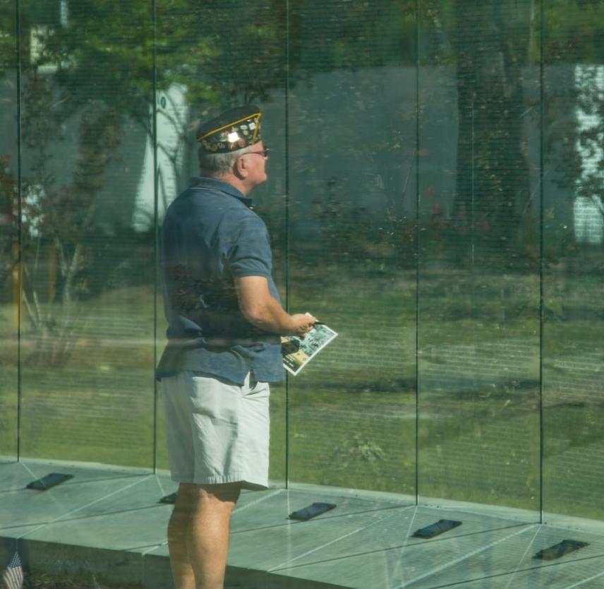 A veteran reads the Glass Wall containing the names of 58,229 Americans killed during the Vietnam War. Vietnam Veterans Recognition Day, Onslow Vietnam Veterans Memorial, Lejeune Memorial Gardens, Jacksonville, NC, 4.27.19. Photo by USMC LCpL Isaiah Gomez