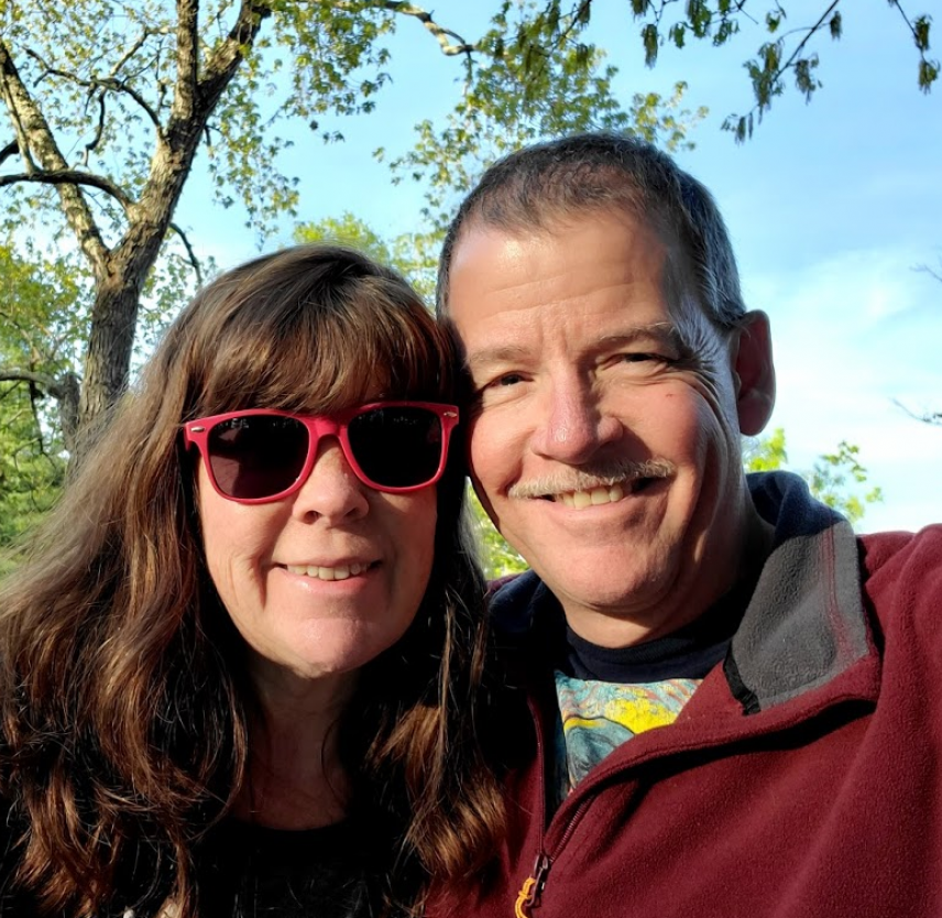 David Grant and his wife smiling at the camera. David Grant and his wife smiling at the camera.
