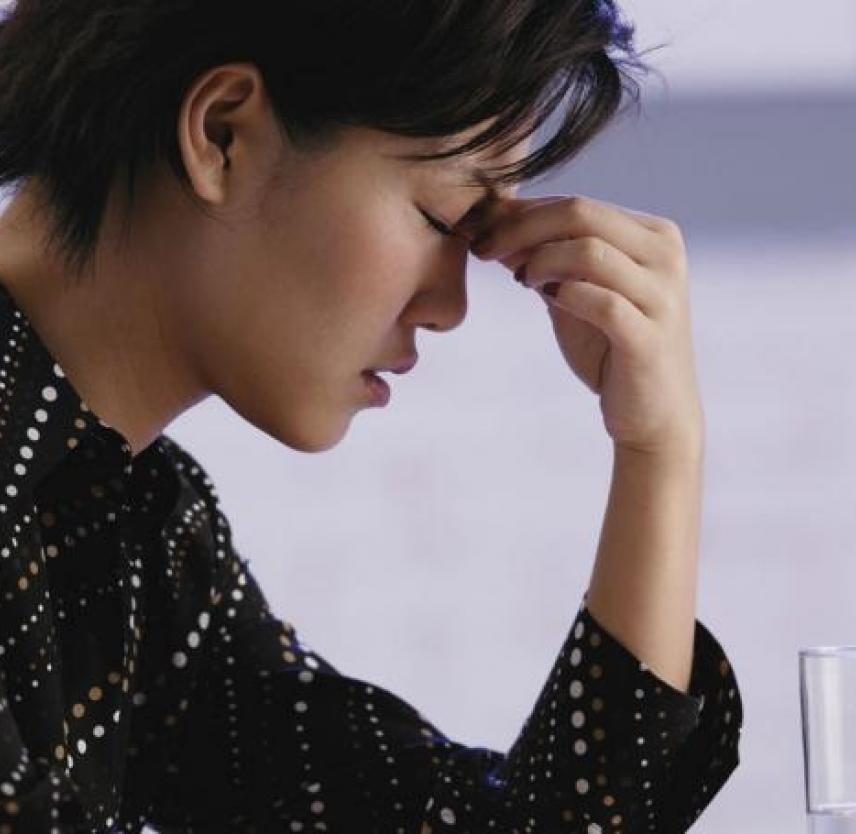 Fatigued woman holding head