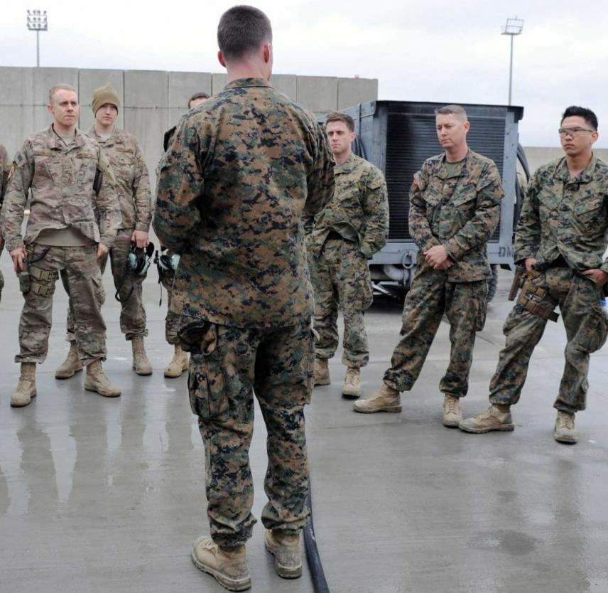 U.S. Marine Corps Capt. Maurice Naylon speaks to a group of Marines and Airmen assigned to the 455th Expeditionary Aircraft Maintenance Unit on the flightline at Bagram Air Field, Afghanistan, 2014. Photo by SSgt. Whitney Amstutz, courtesy U.S. Air Force Marine Capt. Maurice Naylon in uniform speaking to a group at Bagram Air Field, Afghanistan