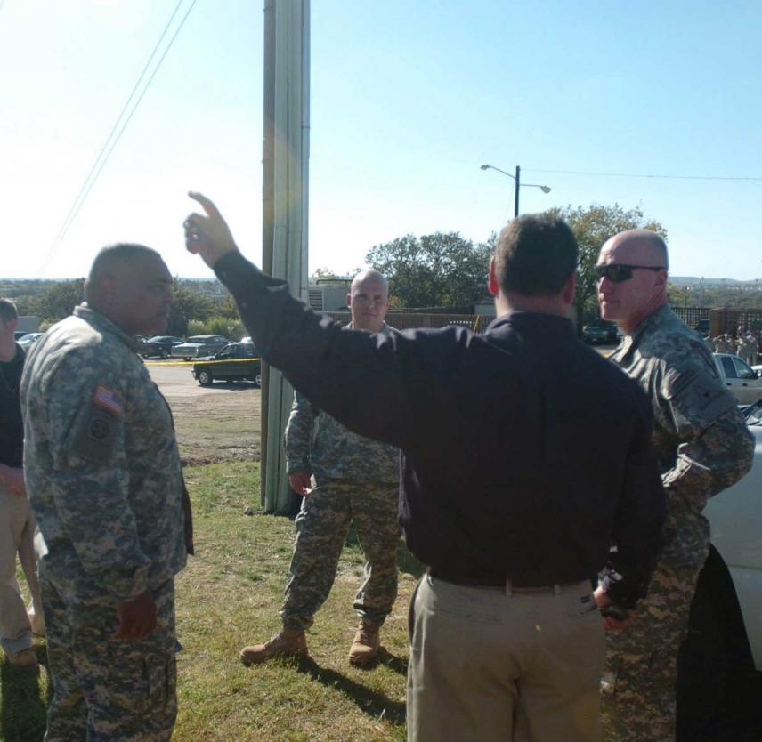 Lt. Gen Robert Cone (right), III Corps commanding general, and Command Sgt. Maj. Arthur L. Coleman Jr., receive a briefing from Fort Hood law enforcement officers, including Eric Tangeman (center), outside the shooting site at Fort Hood. Photo of uniformed military personnel