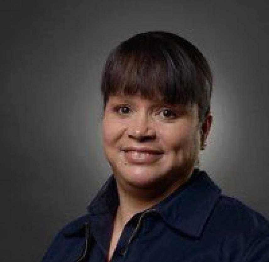 Michelle Gradnigo. Photo courtesy of the author. Professional headshot of Michelle Gradnigo, smiling at the camera wearing a dark blue top.