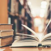 A book lays open on a table in a library