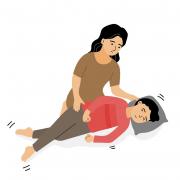 Illustration of a boy having a seizure and mother holding a pillow under his head