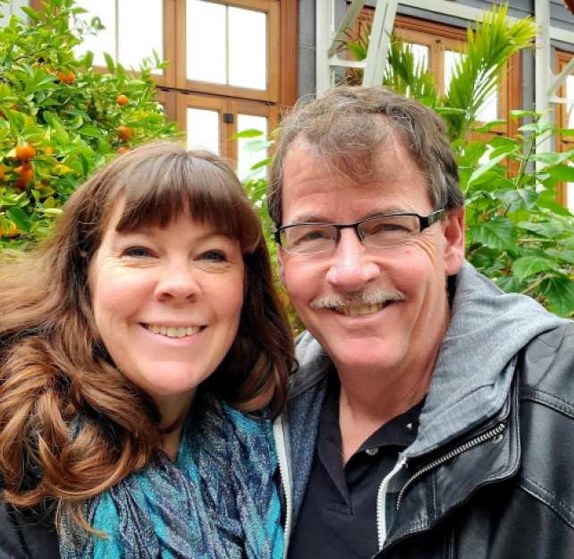David Grant and his wife smiling at camera