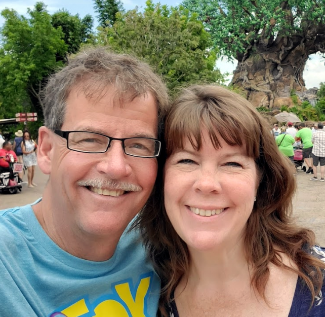 David Grant and his wife smiling at camera