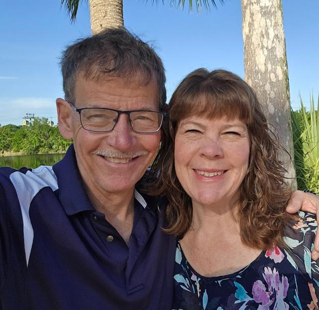 David and his wife smiling at the camera.