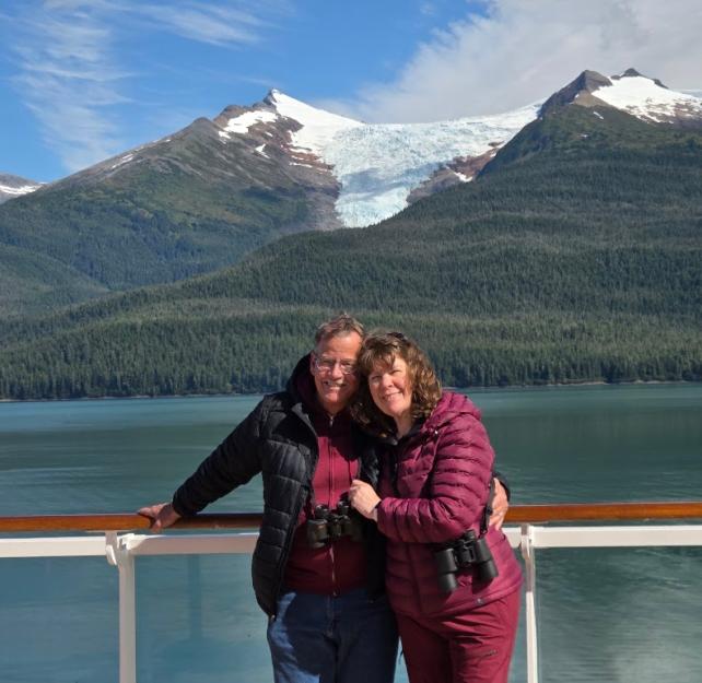 David and his wife in front of a mountain.