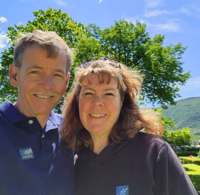 David and his wife smiling in a bright green garden