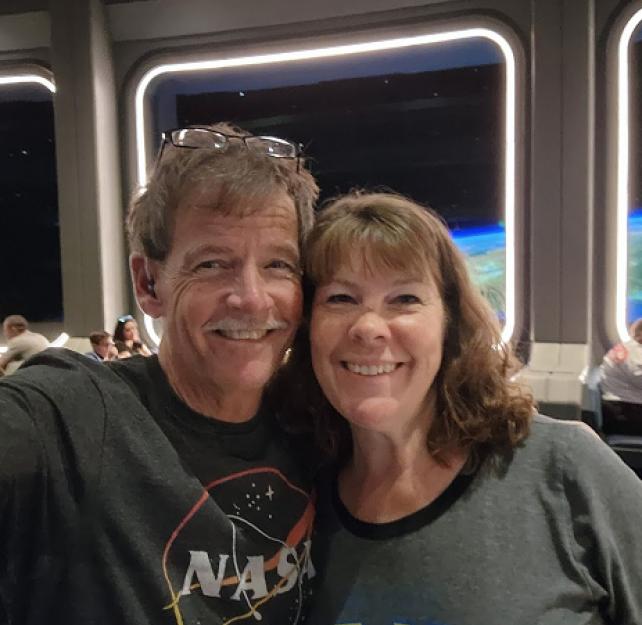 David and his wife smiling from a simulated space station