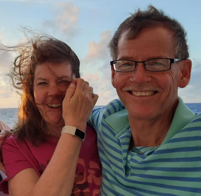 David and his wife smiling, her hair whipping in the wind in front of her face