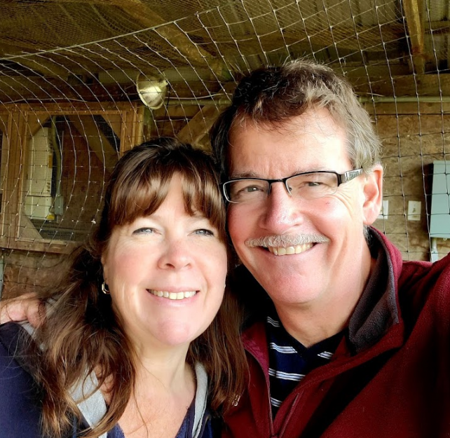 David Grant and his wife smiling at camera