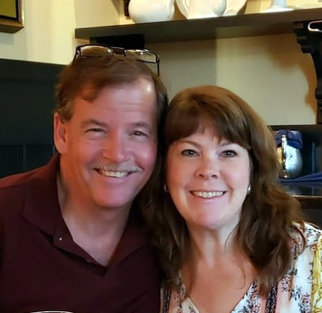 David Grant and his wife smiling at camera