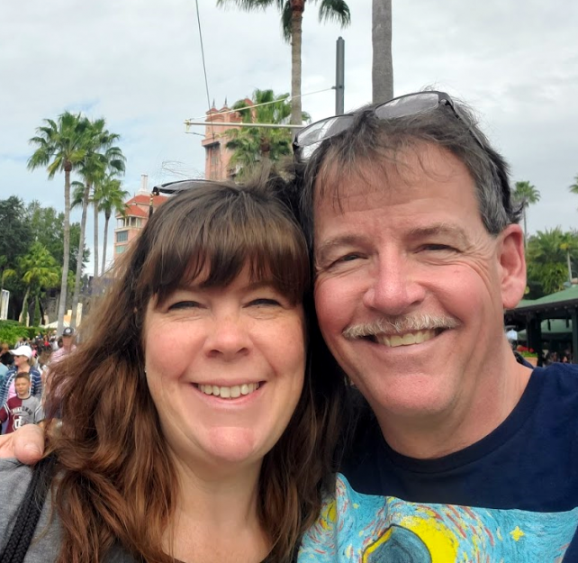David Grant and his wife smiling at camera