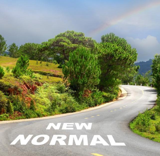 Photo of a rainbow in the upper right over rolling hills and a winding road up a green hill with "New Normal" printed on the asphalt