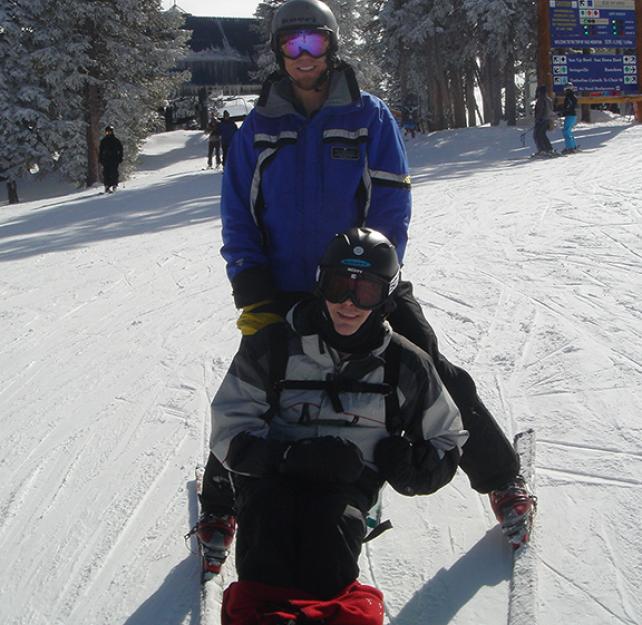 Jason Ehrhart sit-skiing with an instructor