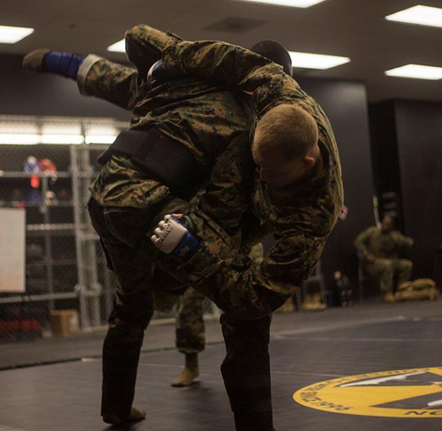 Two Marines engaged in a mixed martial arts throw