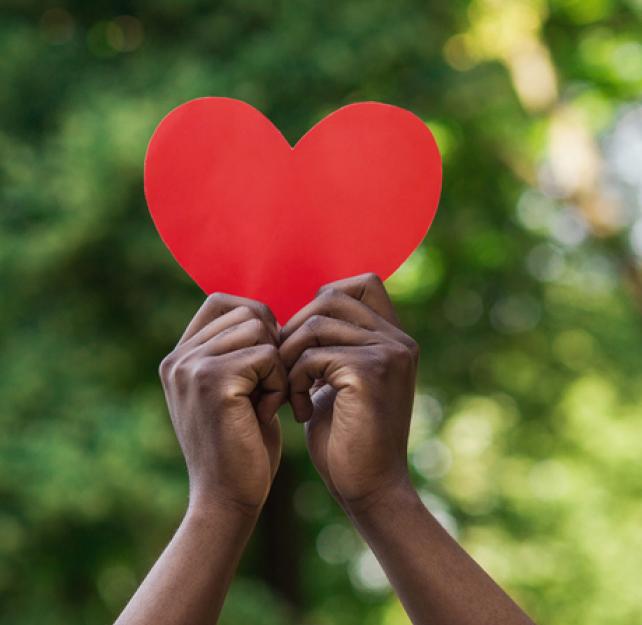 Two hands holding a paper heart